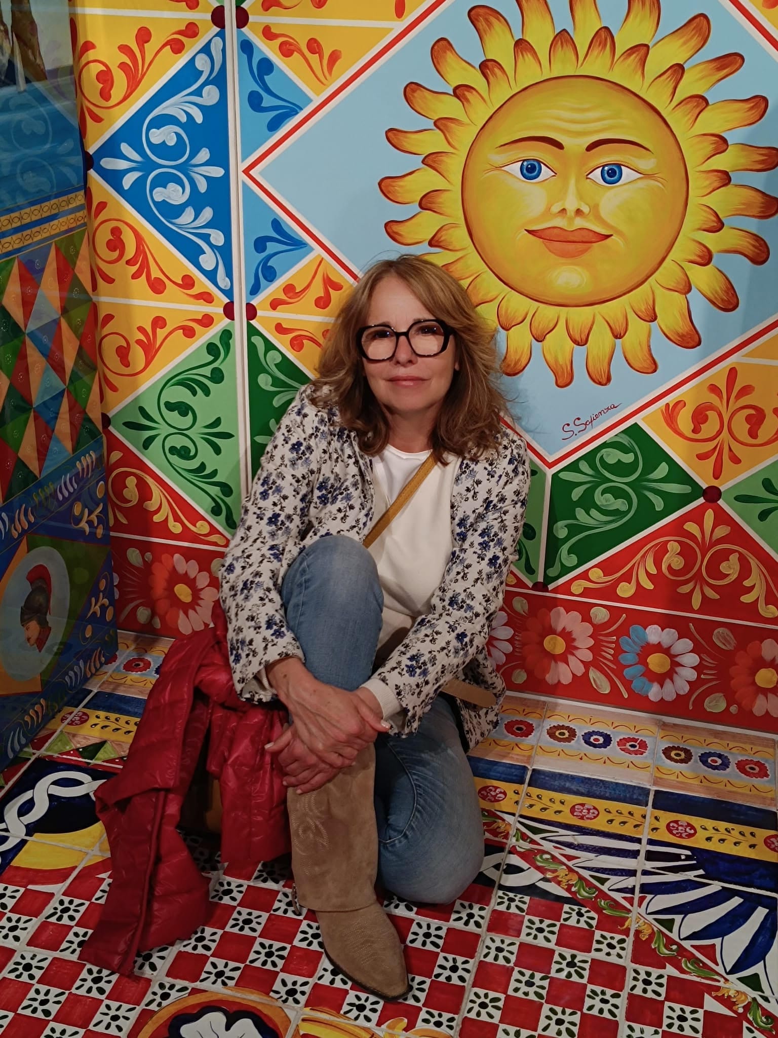 Claudia in front of colorful tile mural